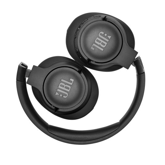 Um par de fones de ouvido JBL Tune 760NC está sobre uma mesa moderna e elegante, com o desempenho da bateria exibido em uma tela digital.