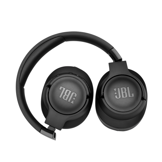 Uma pessoa usando fones de ouvido JBL Tune 760NC enquanto ajusta as configurações de som em um dispositivo digital.